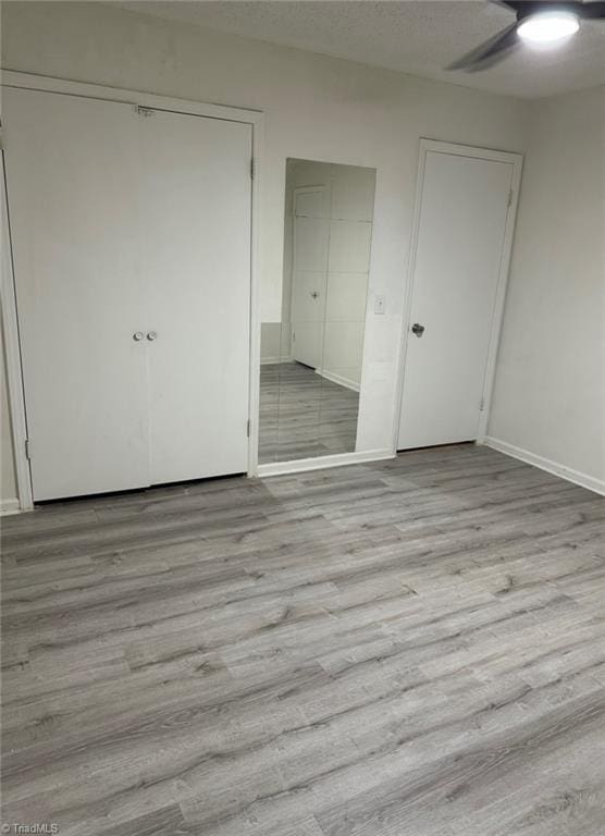 567 Townsend St, North Wilkesboro, NC 28659 - unfurnished bedroom with light wood finished floors, baseboards, a closet, and a ceiling fan