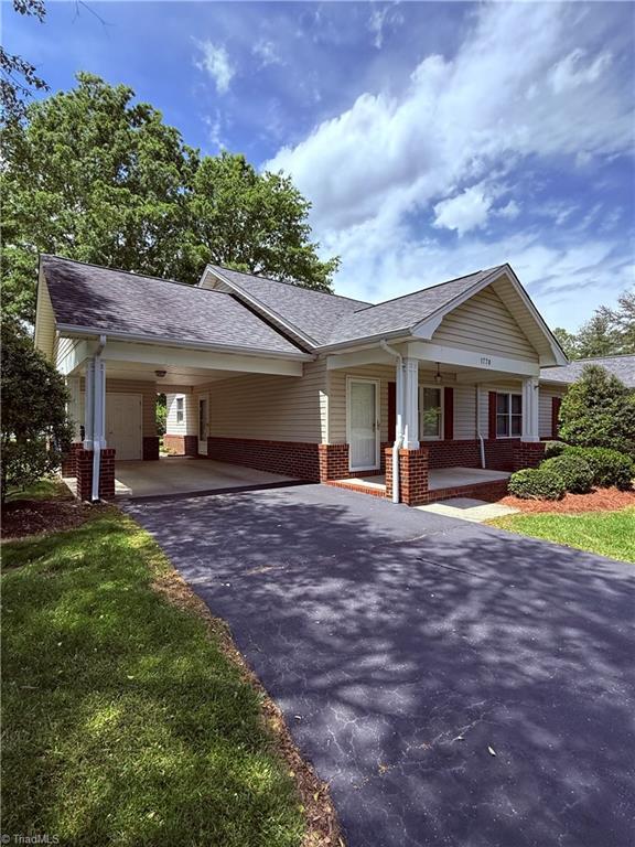1770 Inglebrook Trl, Mount Airy, NC 27030 - view of front of house with brick siding, asphalt driveway, covered porch, a carport, and roof with shingles