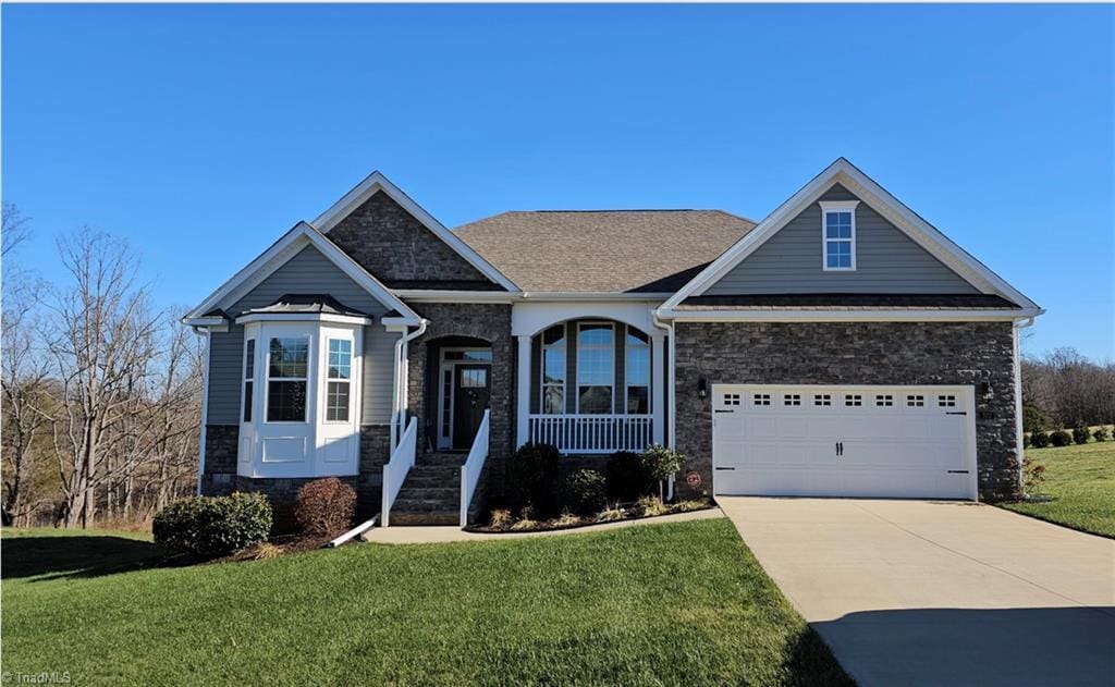 craftsman-style home with a front yard and a garage