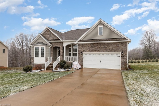 view of front of property featuring covered porch, a garage, and a front lawn