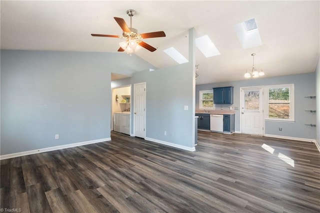 unfurnished living room featuring ceiling fan with notable chandelier, a sink, vaulted ceiling with skylight, baseboards, and dark wood-style flooring