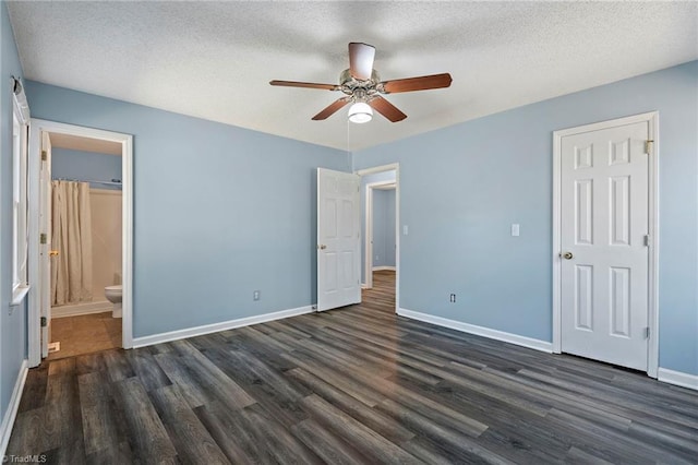 unfurnished bedroom featuring a ceiling fan, a textured ceiling, dark wood-style floors, connected bathroom, and baseboards