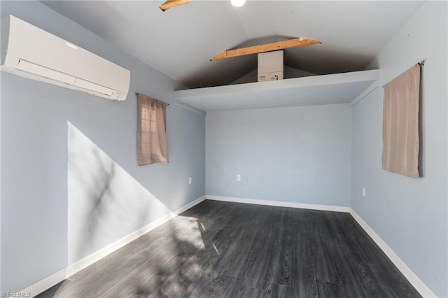 empty room with vaulted ceiling, wood finished floors, baseboards, and a wall mounted air conditioner