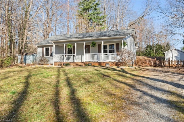 view of front of house with crawl space, covered porch, a front yard, and fence