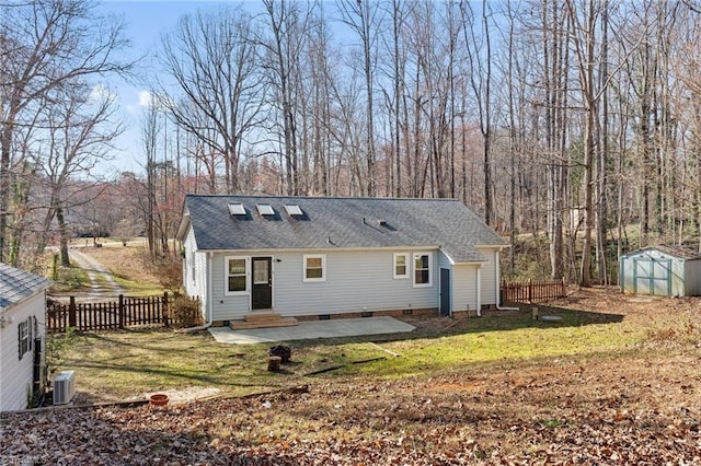 rear view of house with central air condition unit, an outbuilding, entry steps, a patio, and fence