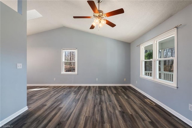 empty room with lofted ceiling, baseboards, a wealth of natural light, and dark wood-type flooring