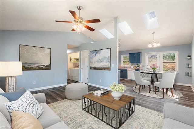 living area with dark wood-style floors, vaulted ceiling with skylight, and baseboards