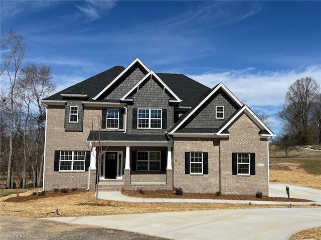 craftsman-style house featuring covered porch, brick siding, and crawl space