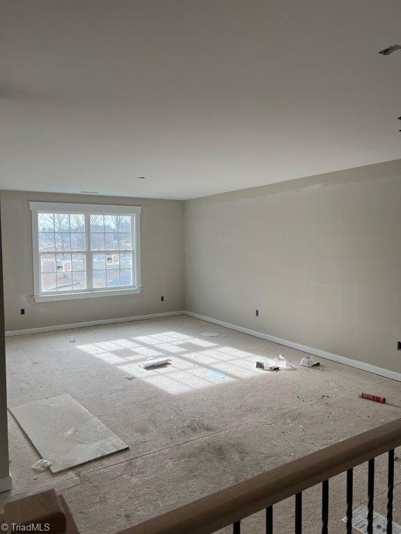 unfurnished room featuring visible vents and baseboards