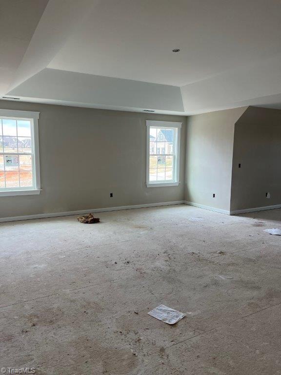 spare room featuring baseboards and a tray ceiling