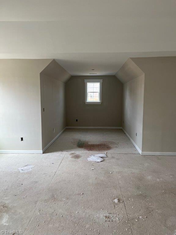 bonus room featuring vaulted ceiling and baseboards