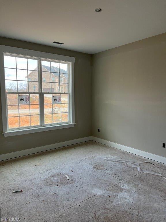 unfurnished room featuring baseboards and visible vents