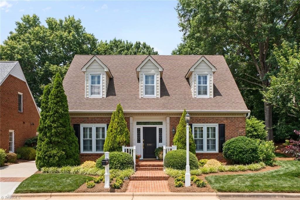 6001 Rittenhouse Rd, Winston-Salem, NC 27104 - cape cod-style house featuring brick siding and roof with shingles