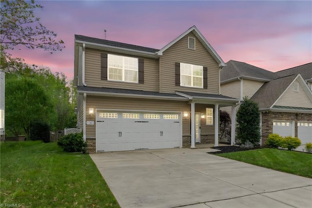 view of front of house with concrete driveway, an attached garage, stone siding, and a front yard