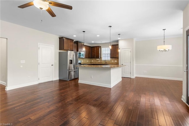 kitchen with stainless steel appliances, dark brown cabinetry, dark wood-style flooring, ceiling fan, and a kitchen island