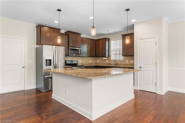 kitchen featuring stainless steel appliances, decorative backsplash, dark brown cabinets, and dark wood finished floors