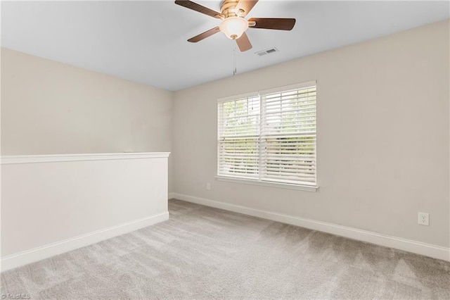 carpeted spare room with ceiling fan, baseboards, and visible vents