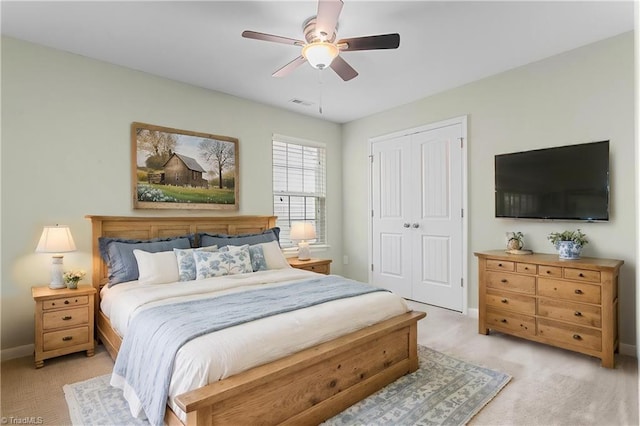 bedroom featuring light colored carpet, a closet, and baseboards
