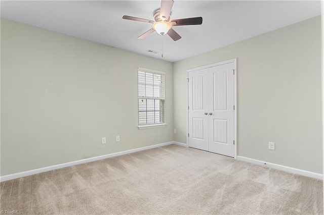 unfurnished bedroom with baseboards, a closet, visible vents, and light colored carpet
