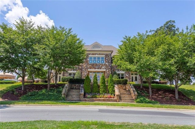 view of front of home with stone siding and stairs