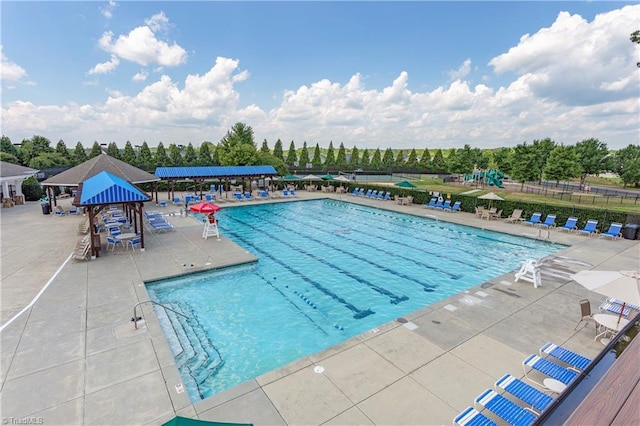 pool with fence, a patio, and playground community