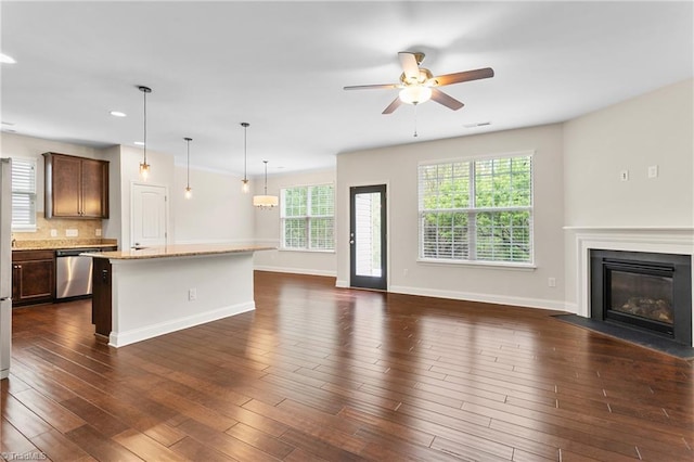 unfurnished living room featuring recessed lighting, baseboards, ceiling fan, a fireplace with flush hearth, and dark wood-style floors