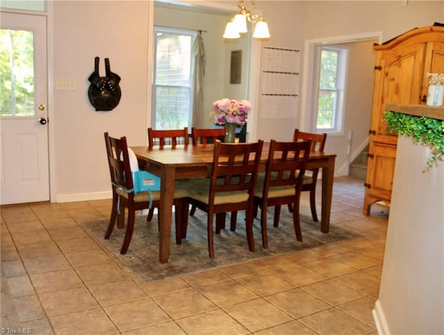 tiled dining space featuring an inviting chandelier