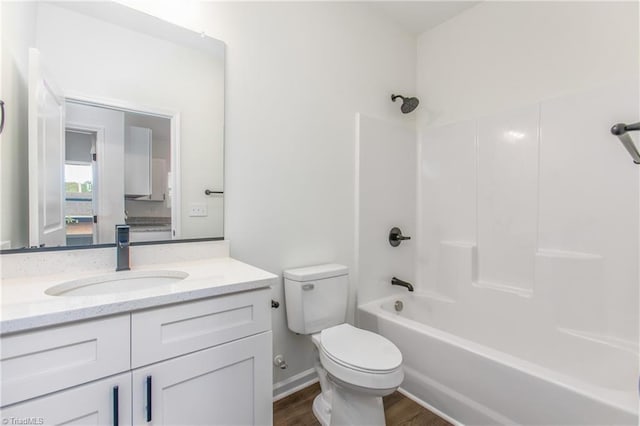 full bath featuring toilet, washtub / shower combination, wood finished floors, and vanity