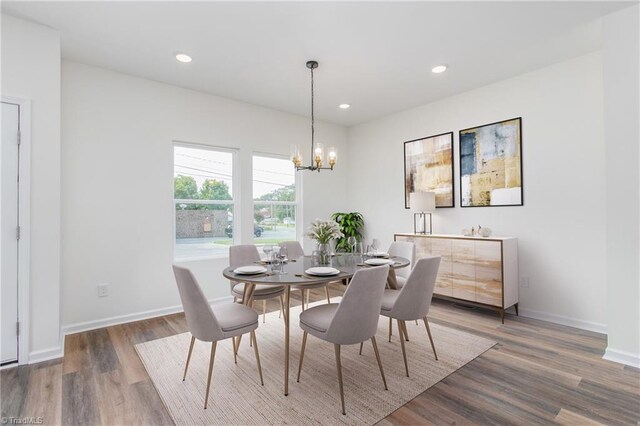 dining room with recessed lighting, baseboards, a notable chandelier, and wood finished floors