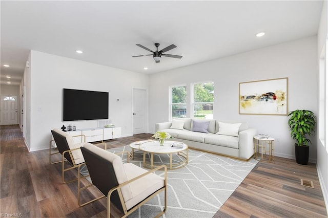 living room with recessed lighting, visible vents, baseboards, and wood finished floors