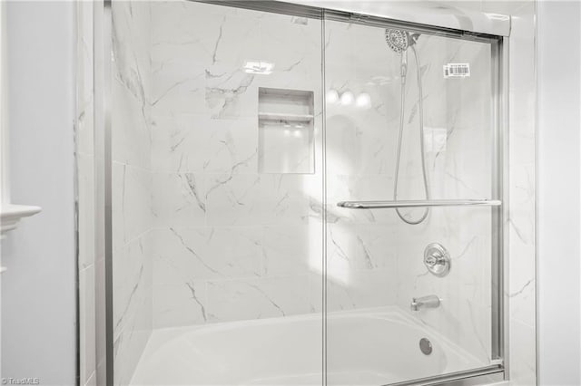 bathroom with shower / bath combination with glass door