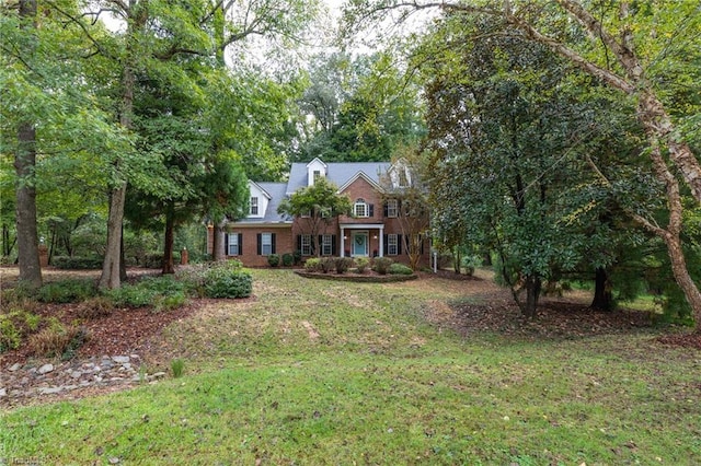 cape cod house with a front yard