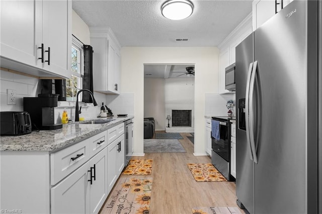 kitchen with sink, white cabinetry, stainless steel appliances, and tasteful backsplash