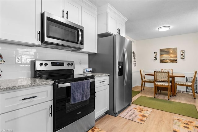 kitchen featuring light stone countertops, appliances with stainless steel finishes, a textured ceiling, light hardwood / wood-style flooring, and white cabinets