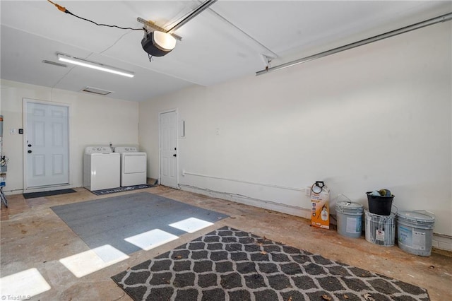 garage with separate washer and dryer and a garage door opener