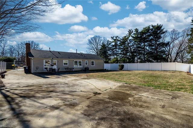 back of property with a yard and a patio