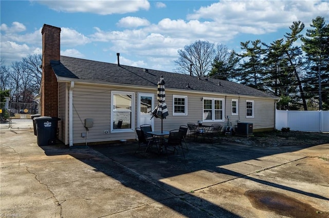 rear view of house with central AC unit and a patio area