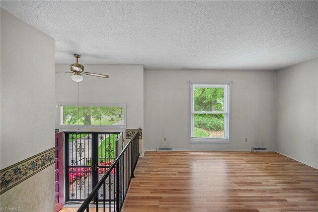 4904 Kacia Ct, Greensboro, NC 27407 - spare room featuring a ceiling fan, a textured ceiling, visible vents, and wood finished floors