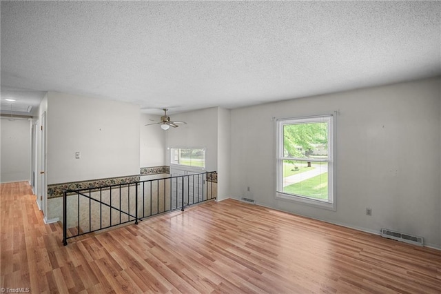 4904 Kacia Ct, Greensboro, NC 27407 - spare room featuring visible vents, a textured ceiling, wood finished floors, and a healthy amount of sunlight