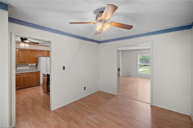 4904 Kacia Ct, Greensboro, NC 27407 - unfurnished room featuring light wood-type flooring, a ceiling fan, and a textured ceiling