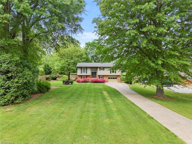 4904 Kacia Ct, Greensboro, NC 27407 - split foyer home featuring fence, an attached garage, concrete driveway, and a front lawn