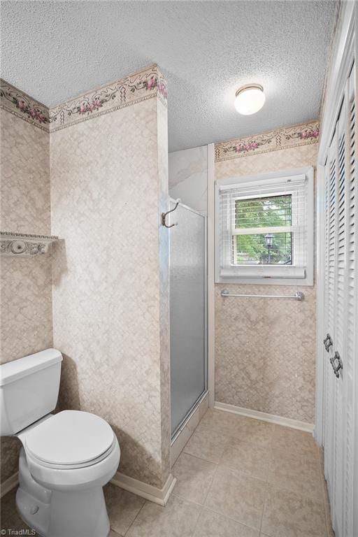 4904 Kacia Ct, Greensboro, NC 27407 - full bathroom with tile patterned flooring, a textured ceiling, a stall shower, and toilet