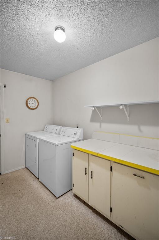 4904 Kacia Ct, Greensboro, NC 27407 - washroom featuring a textured ceiling and washing machine and clothes dryer