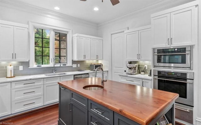 kitchen with white cabinets, crown molding, sink, and decorative backsplash