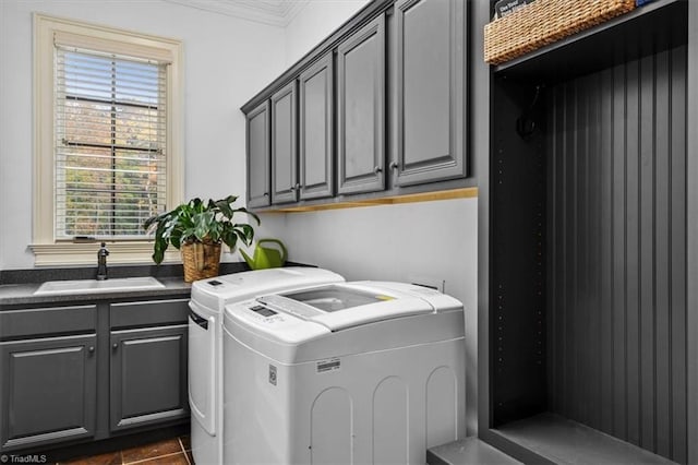 laundry area featuring dark tile patterned flooring, cabinets, sink, ornamental molding, and independent washer and dryer