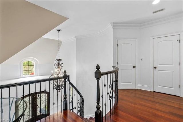 hallway with crown molding, dark hardwood / wood-style flooring, and a notable chandelier