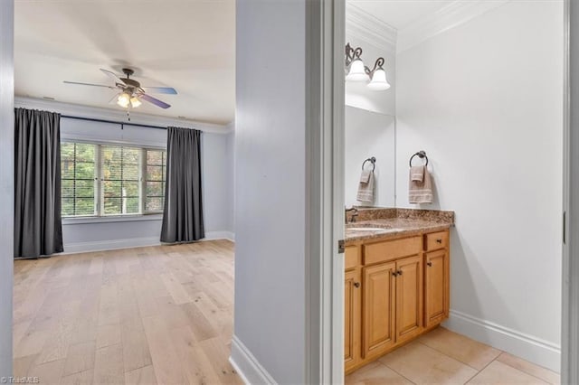 bathroom with ceiling fan, wood-type flooring, vanity, and crown molding