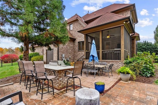 view of patio featuring a sunroom and ceiling fan