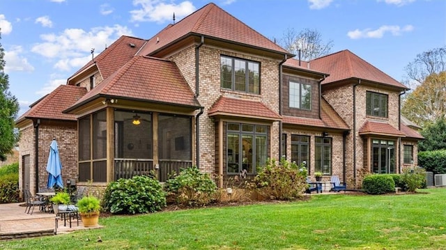 rear view of property with a sunroom and a yard