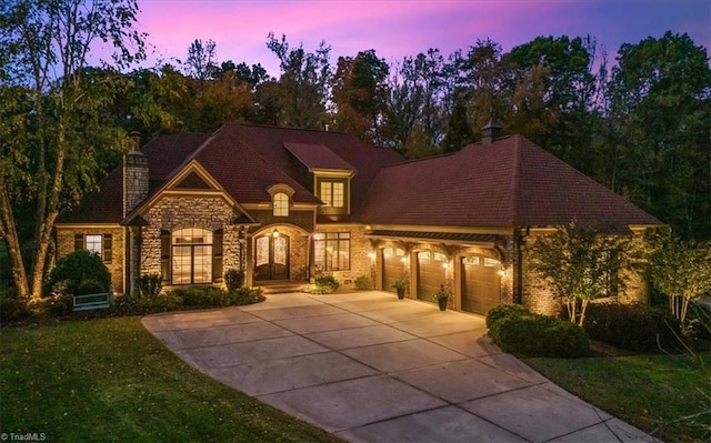 view of front of property featuring a garage and a yard